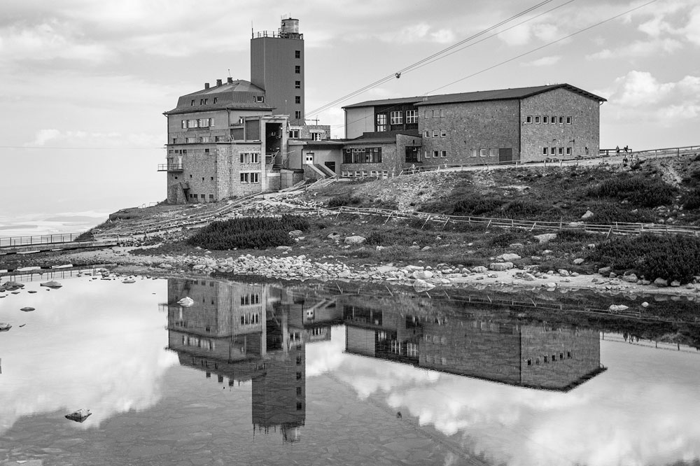 Krajina s budovami a odrazom vo vode — pred aplikovaním čiernobieleho presetu